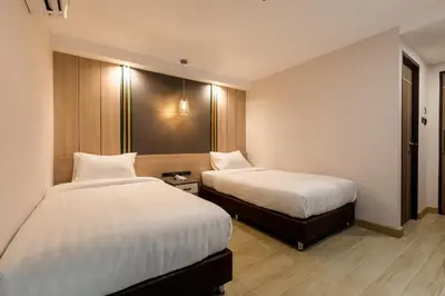 a hotel room with two beds and a table at City Park Hotel Bangkok Pratunam by PCL in Bangkok