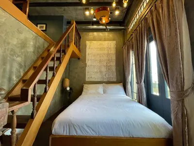 a bedroom with a bed next to a staircase at Central Old Town Cottage in Bangkok