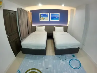 a small room with two beds in it at Poonsuk Place Hotel in Bangkok Noi