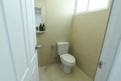 a small bathroom with a toilet and a window at Poonsuk Place Hotel in Bangkok Noi