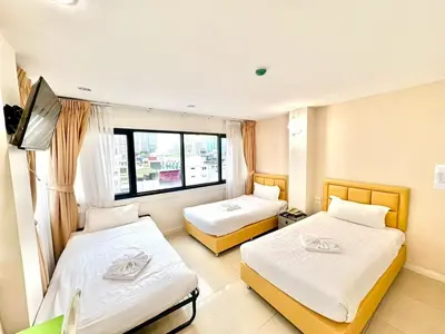 a hotel room with two beds and a television at ABCYQ Hotel in Bangkok