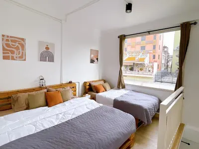 two beds in a room with a window at Lively and cozy canal house ,Entire house in Bangkok