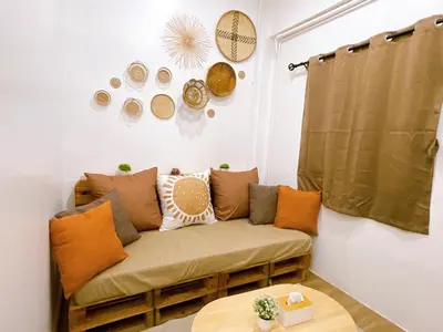 a living room with a couch and plates on the wall at Lively and cozy canal house ,Entire house in Bangkok