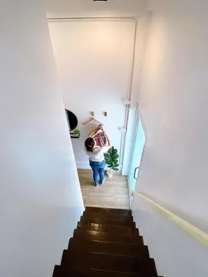 a person walking down a staircase in a house at Lively and cozy canal house ,Entire house in Bangkok