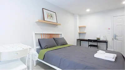 a small bedroom with a bed and a desk at Peaberry Place - พีเบอร์รี่เพลส in Ban Zong Katiam