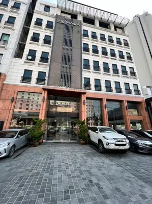 a large building with cars parked in front of it at Sukhothai Hotel and Residence Ratchada in Bangkok