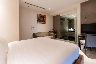 a hotel room with a bed and a television at Sukhothai Hotel and Residence Ratchada in Bangkok