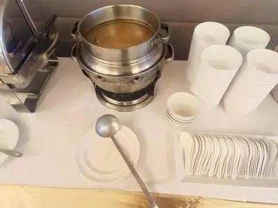 a pot on a counter with plates and cups at Sukhothai Hotel and Residence Ratchada in Bangkok