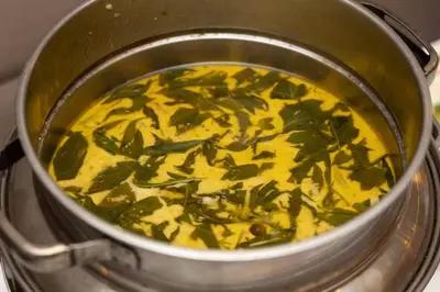 a pot filled with yellow liquid with green leaves at Sukhothai Hotel and Residence Ratchada in Bangkok