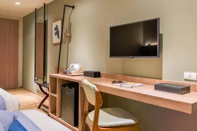 a hotel room with a desk with a television on it at Bella B Hotel in Nonthaburi