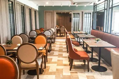 a row of tables and chairs in a restaurant at Bella B Hotel in Nonthaburi