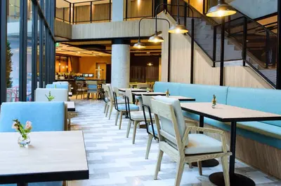 a row of tables and chairs in a restaurant at Bella B Hotel in Nonthaburi