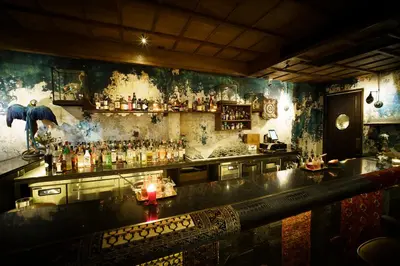a bar with a lot of bottles on the wall at Baan Tuk Din Hotel in Bangkok