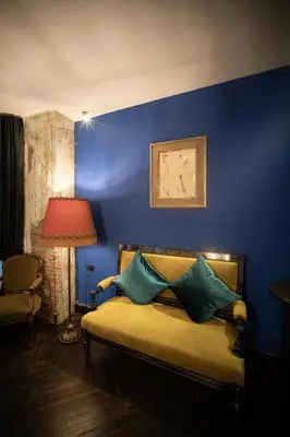 a blue bedroom with a bed with a red lamp at Baan Tuk Din Hotel in Bangkok