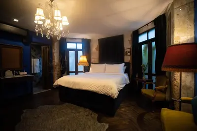 a bedroom with a bed and a chandelier at Baan Tuk Din Hotel in Bangkok