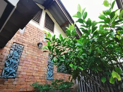 a brick building with a tree in front of it at Sri Ayuttaya Guesthouse in Bangkok