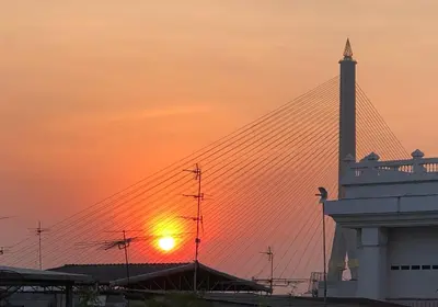 an airport with the sunset in the background at Sri Ayuttaya Guesthouse in Bangkok