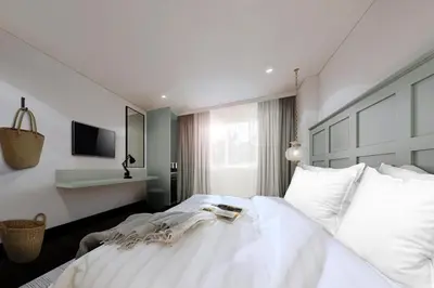 a bedroom with a large white bed and a window at Forgotten Hostel Silom in Bang Rak