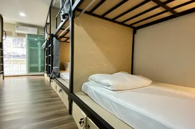 a room with two bunk beds and a hallway at Forgotten Hostel Silom in Bang Rak