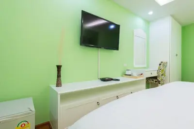 a green room with a television on the wall at Sabai Dee Minitel in Dusit