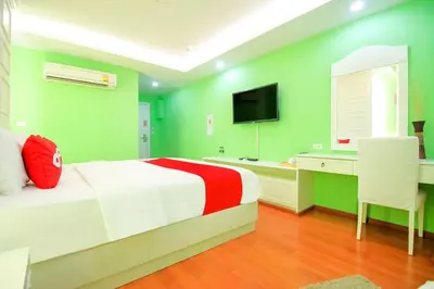 a green and white bedroom with a bed and a desk at Sabai Dee Minitel in Dusit