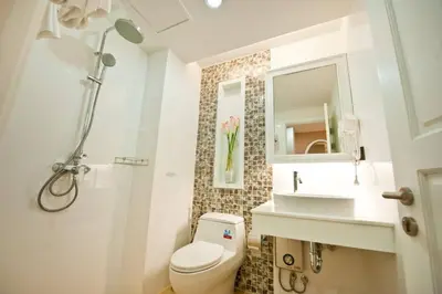 a bathroom with a toilet and a sink and a shower at Sabai Dee Minitel in Dusit