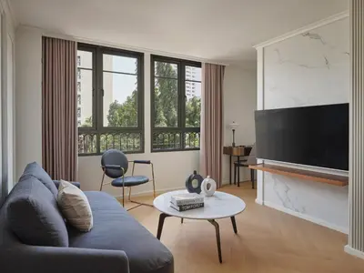 a living room with a couch and a tv at The Alberti Hotel - Sukhumvit 31 in Bangkok