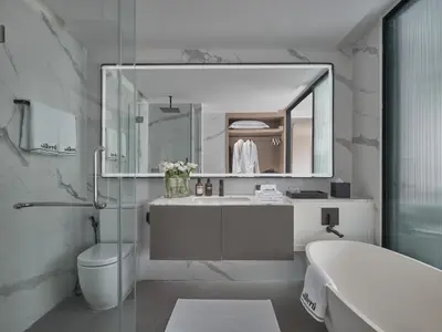 a bathroom with a sink and a toilet and a mirror at The Alberti Hotel - Sukhumvit 31 in Bangkok