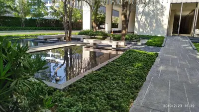 a courtyard with a pond in front of a building at Sathon Luxury High-rise Apartment City View KingPower ,IconSiam ,BNH,Silom in Bangkok