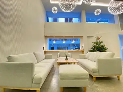 a living room with two couches and a christmas tree at Ascella Bangkok Hotel in Makkasan