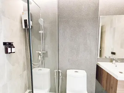 a bathroom with a shower with a toilet and a sink at Ascella Bangkok Hotel in Makkasan