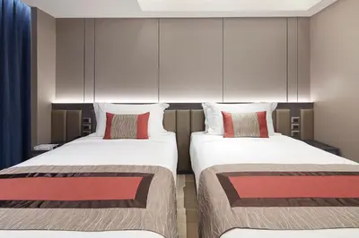 two beds in a hotel room with two pillows at Grace At Five by Grace Hotel Bangkok in Bangkok