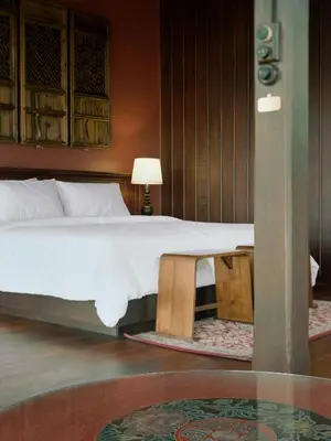 a bedroom with a large bed and a table at neil niwas in Bangkok