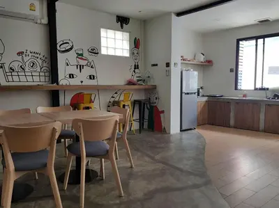 a kitchen with a table and chairs and a refrigerator at All day hostel at BTS Bang Chak in Bangkok