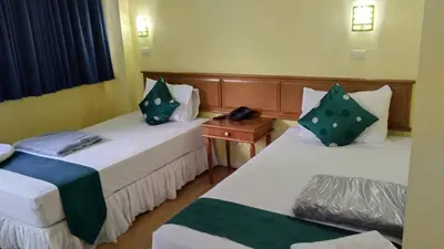 a room with two beds and a telephone in it at Asia Inn Bangkok 2022 in Bangkok