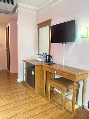 a wooden desk with a television on a wall at Asia Inn Bangkok 2022 in Bangkok