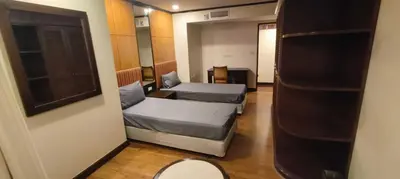 a small room with two beds and a mirror at Omni Tower Nana Bangkok - Serviced Apartment on Sukhumvit Soi 4 in Bangkok