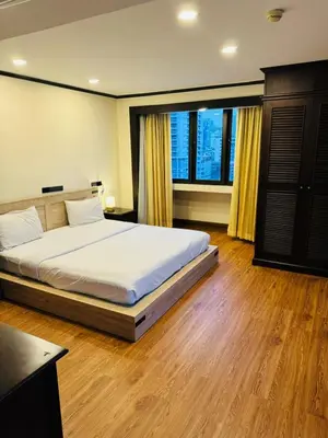 a bedroom with a bed and a large window at Omni Tower Nana Bangkok - Serviced Apartment on Sukhumvit Soi 4 in Bangkok