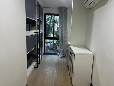 a kitchen with a counter and a door to a window at Owl's Nest suk 30 in Bangkok