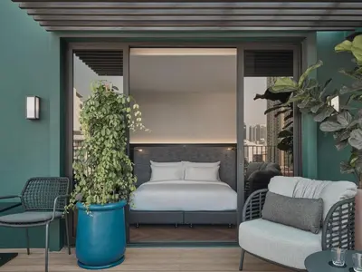 a bedroom with a bed on a balcony at Public House Bangkok, a Member of Design Hotels in Bangkok