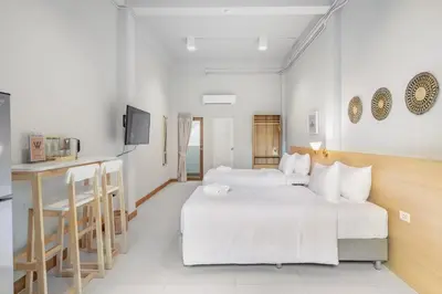 a hotel room with two beds and a kitchen at Hotel Wizpark Ratchada in Bangkok