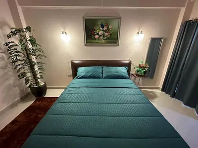 a bedroom with a green bed with a plant on it at 66 Apartment in Ban Khlong Nong Yai