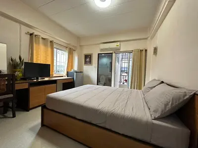 a bedroom with a bed and a desk with a computer at 66 Apartment in Ban Khlong Nong Yai