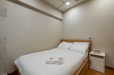 a bedroom with a bed with two slippers on it at C2 stay Phayathai in Pom Prap