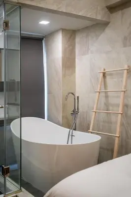 a bath tub in a bathroom with a glass wall at C2 stay Phayathai in Pom Prap