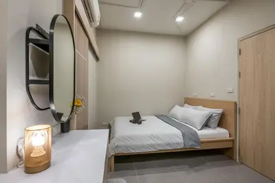 a small bedroom with a bed and a mirror at C2 stay Phayathai in Pom Prap