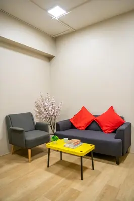 a living room with a couch and a chair and a table at C2 stay Phayathai in Pom Prap
