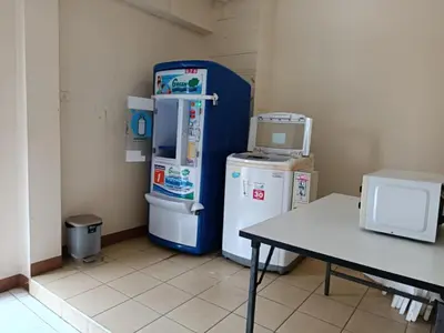 a room with two refrigerators sitting next to a table at Grandview Condominia in Bangkok