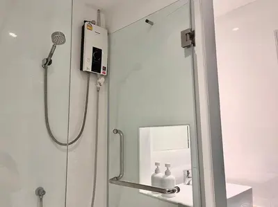 a shower in a bathroom with a mirror at Aowmana Hotel in Makkasan