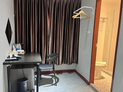 a desk and a chair in front of a curtain at Aowmana Hotel in Makkasan